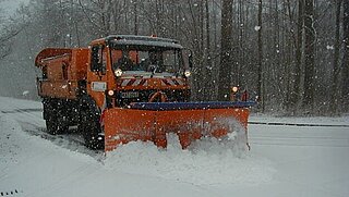 Räumfahrzeug im Einsatz auf verschneiter Straße