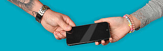 Eine Hand hält ein Smartphone und übergibt es einer anderen Hand